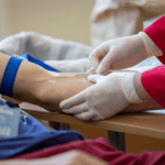 Medical specialist performing a lower leg examination to diagnose peripheral neuropathy and assess nerve function in a clinical setting.