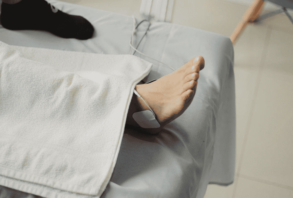 Illustration showing electrical nerve stimulation reducing pain signals from damaged feet affected by peripheral neuropathy.