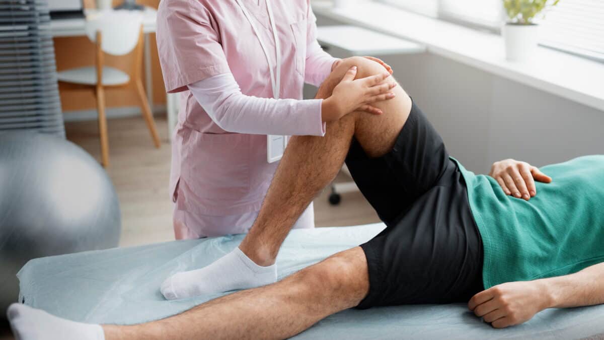 Physical therapist performing a knee assessment during non-surgical rehabilitation for knee pain