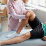Physical therapist performing a knee assessment during non-surgical rehabilitation for knee pain