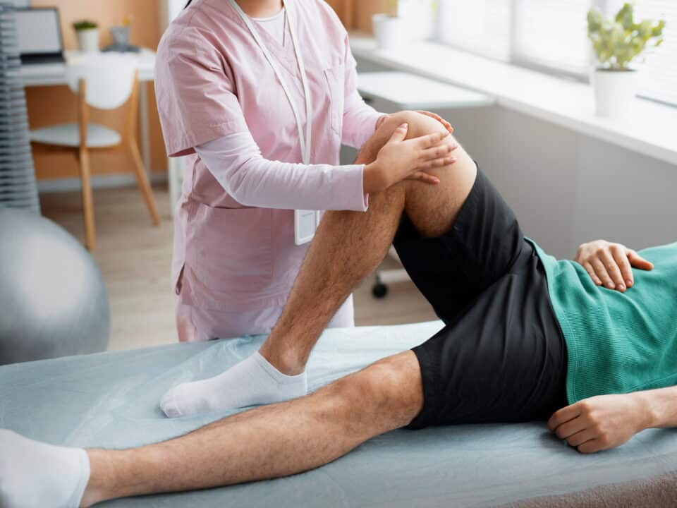 Physical therapist performing a knee assessment during non-surgical rehabilitation for knee pain